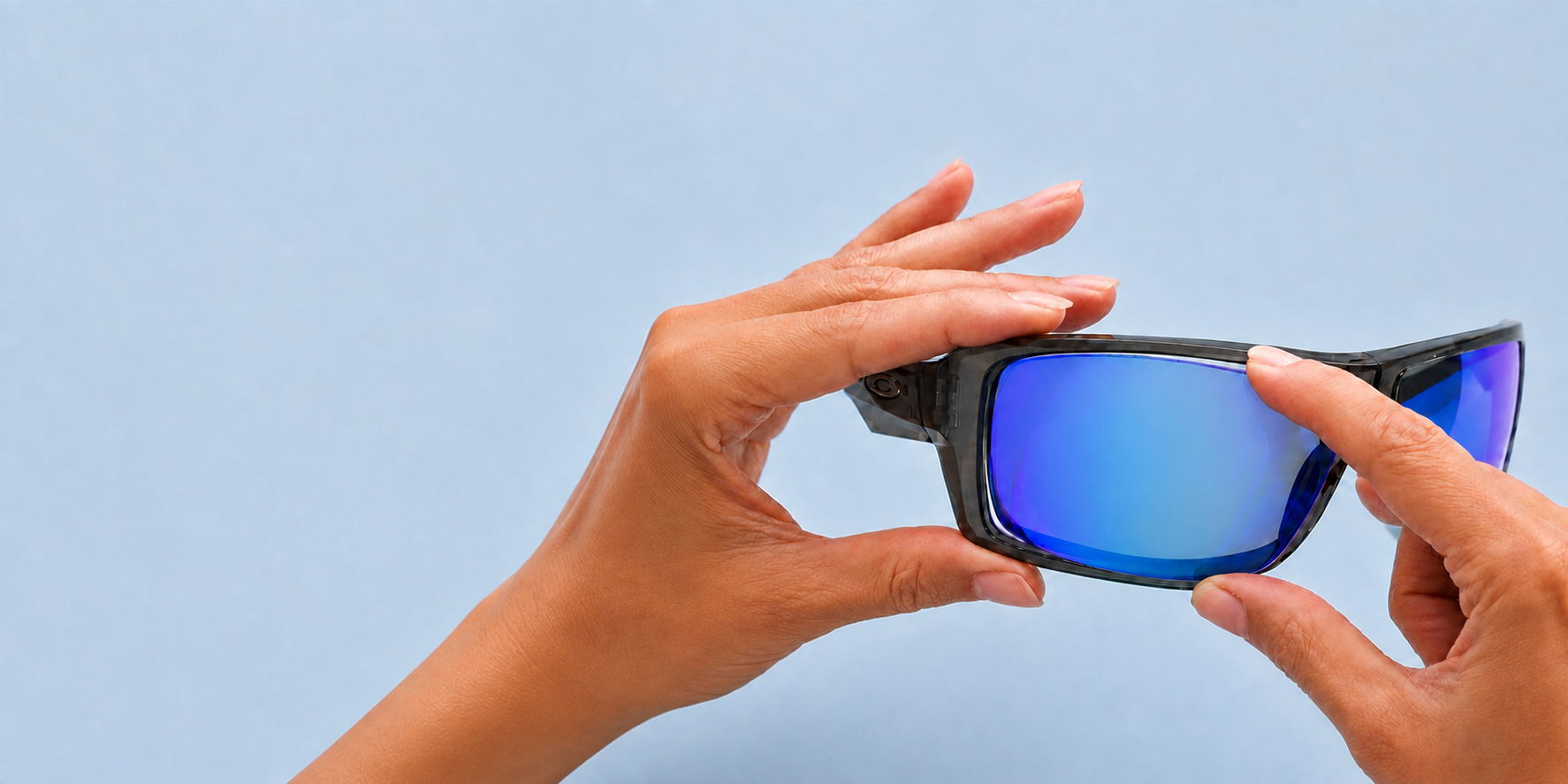 Hands fitting a blue replacement lens into a sunglass frame